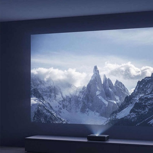 An image of the laser projector lighting up the wall with an image of mountains covered in snow.